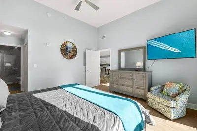 a bedroom with a bed and a flat screen tv at Tidewater Resort! Ground Floor! Free Beach Chairs! by Dolce Vita Getaways PCB in Panama City Beach