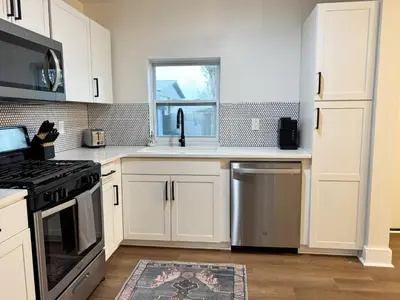 a kitchen with white cabinets and a stove top oven at Dreami Stays Panama City - 2BR Retreat Near Downtown, Beaches, & Hot Spots in Panama City