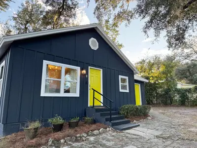 a black tiny house with a yellow door at Dreami Stays Panama City - 2BR Retreat Near Downtown, Beaches, & Hot Spots in Panama City