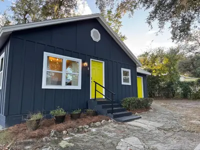 a black tiny house with a yellow door at Dreami Stays Panama City - 2BR Retreat Near Downtown, Beaches, & Hot Spots in Panama City