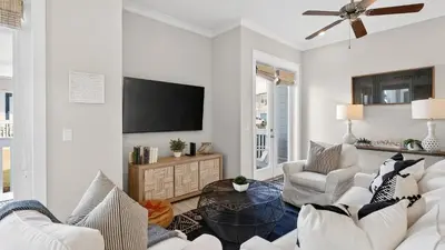 a living room with white furniture and a flat screen tv at Arcade Bar Prominence Resort Pool and Gym Access Close to Beach Sea Happy in Watersound Beach