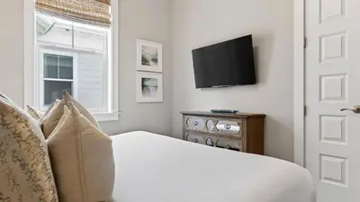 a bedroom with a bed and a television on a wall at Arcade Bar Prominence Resort Pool and Gym Access Close to Beach Sea Happy in Watersound Beach