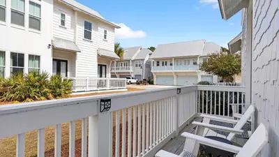 a balcony with a white fence and houses at Arcade Bar Prominence Resort Pool and Gym Access Close to Beach Sea Happy in Watersound Beach