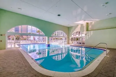 a large swimming pool in a building with a large window at Celadon Beach 2107 in Panama City Beach