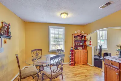 a dining room with a table and chairs and a kitchen at Sunny Panama City Escape with Pool and Deck! in Panama City