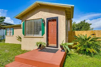 a tiny house with a red door in a yard at Sunny Panama City Escape with Pool and Deck! in Panama City