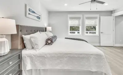 a white bedroom with a large bed and two windows at 10 Joanna Sophisticated Seagrove Beach pool sleeps 14 in Santa Rosa Beach