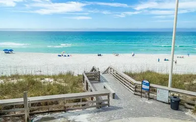 a boardwalk leading to a beach with people on it at 10 Joanna Sophisticated Seagrove Beach pool sleeps 14 in Santa Rosa Beach