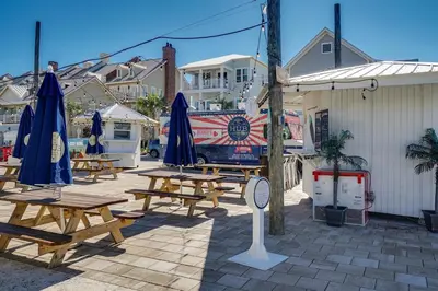 a group of picnic tables with umbrellas on a patio at Inns at Seacrest 210 in Seacrest