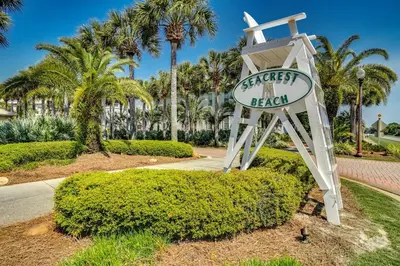 a sign for a resort with palm trees in the background at Inns at Seacrest 210 in Seacrest