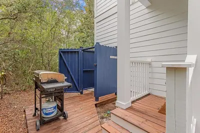 a grill on a deck next to a house at Seagrove Retreat - Steps to Beach, Pool, and Seaside in Santa Rosa Beach