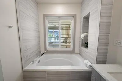 a white bath tub in a bathroom with a window at The Pointe at Rosemary Beach 332 in Rosemary Beach