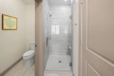 a bathroom with a toilet and a walk in shower at The Pointe at Rosemary Beach 332 in Rosemary Beach