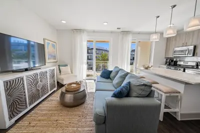 a living room with a blue couch and a kitchen at The Pointe at Rosemary Beach 332 in Rosemary Beach