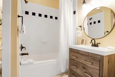 a bathroom with a tub and a sink and a mirror at Palazzo 30A in Santa Rosa Beach