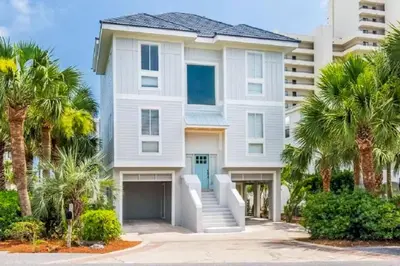 a white house with palm trees in front of it at Palazzo 30A in Santa Rosa Beach