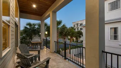 a porch with chairs and a table on a balcony at Palazzo 30A in Santa Rosa Beach
