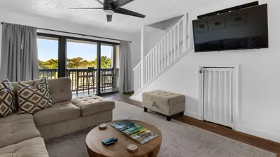 a living room with a couch and a tv at Palm Sounds in Inlet Beach