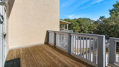 a balcony of a house with a wooden deck at Palm Sounds in Inlet Beach
