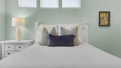 a bedroom with a white bed with pillows at 448 Beach Bike Way in Rosemary Beach