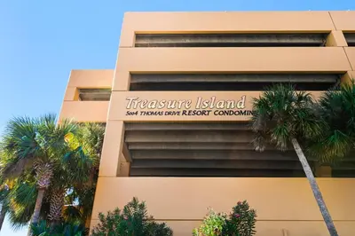a sign on the side of a building with palm trees at Treasure Island Unit 905 (2/2) in Panama City Beach