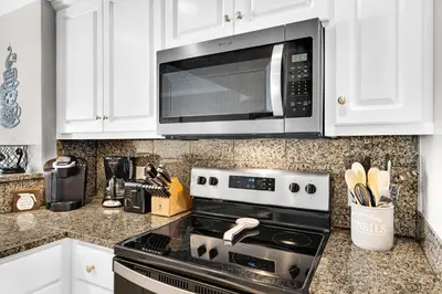 a kitchen with a stove and a microwave at Treasure Island Unit 905 (2/2) in Panama City Beach