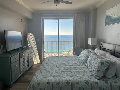 a bedroom with a bed and a view of the ocean at Sunrise Beach Condo -Gulf front- free beach chair service in Panama City Beach