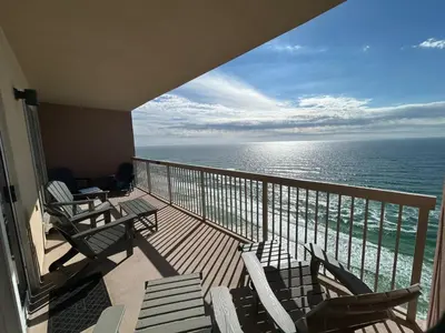 a balcony with chairs and a view of the ocean at Sunrise Beach Condo -Gulf front- free beach chair service in Panama City Beach