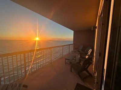 a balcony on a cruise ship with a sunset at Sunrise Beach Condo -Gulf front- free beach chair service in Panama City Beach