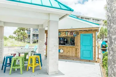 a patio with a table and chairs and a building at Dunes of Panama 1104E in Panama City Beach