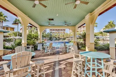 a patio with tables and chairs and a pool at Available for Season! Hi Beautiful Ciao Bella at Seacrest in Inlet Beach