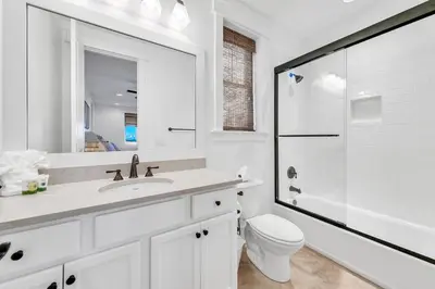 a white bathroom with a toilet and a shower at Available for Season! After Dune Delight at Nature Walk in Santa Rosa Beach