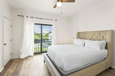 a bedroom with a bed and a large window at Available for Season! One Life One Love Gulf-Front Townhome in Seagrove Beach