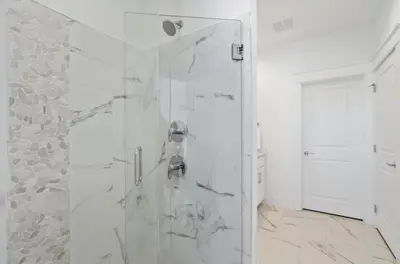 a white bathroom with a shower with a glass door at The Richest Peasant at Inlet Beach in Inlet Beach