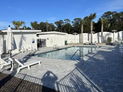 a shadow of a person standing next to a swimming pool at NEW Pool 4 BDR Golf Cart in Inlet Beach