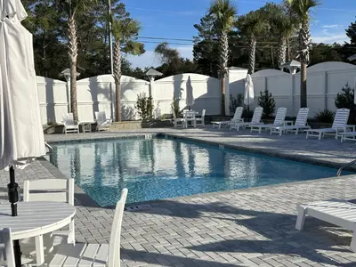 a swimming pool with white chairs and tables and chairs at NEW Pool 4 BDR Golf Cart in Inlet Beach