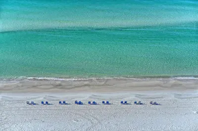 a group of chairs on a beach near the ocean at NEW Pool 4 BDR Golf Cart in Inlet Beach