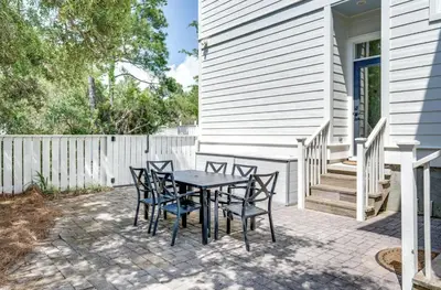 a patio with a table and chairs next to a house at Available for Season! Seagrove Harbor 30A - Private Pool in Seagrove Beach