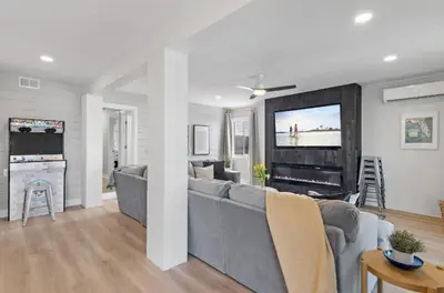a living room with a gray couch and a tv at Available for Season! Sand Castle at Seagrove Beach in Santa Rosa Beach
