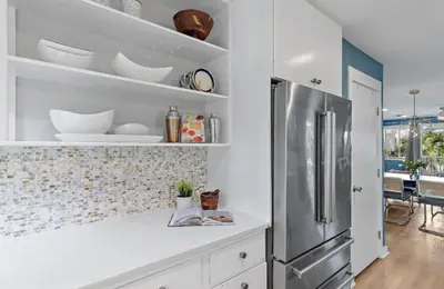 a kitchen with a stainless steel refrigerator and white cabinets at Available for Season! Sand Castle at Seagrove Beach in Santa Rosa Beach