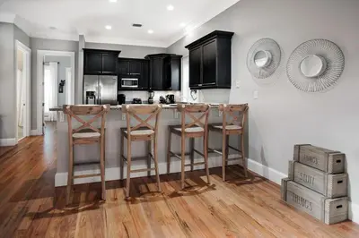 a kitchen with a bar with stools in it at You've Hit The Vacay Jackpot with This Sure Winner! in Rosemary Beach