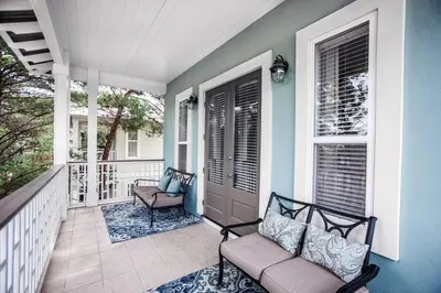 a porch with two chairs and a door on a house at You've Hit The Vacay Jackpot with This Sure Winner! in Rosemary Beach