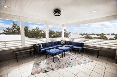 a screened in porch with blue chairs and windows at You've Hit The Vacay Jackpot with This Sure Winner! in Rosemary Beach