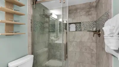 a bathroom with a shower with a toilet and a sink at Sand Cliffs 108 in Seacrest