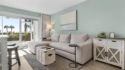 a living room with a couch and a table at Sand Cliffs 108 in Seacrest