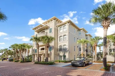 a large building with palm trees in front of it at Available for Season. Gone Coastal at Seacrest in Inlet Beach