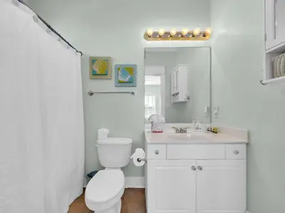 a white bathroom with a toilet and a sink at Penthouse Paradise Condo at Seacrest in Rosemary Beach