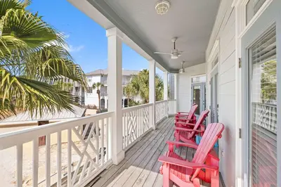 a porch with three red rocking chairs on it at Seacrest Beach Gem with Shared Pool and Game Room in Seacrest