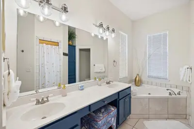 a bathroom with a sink and a tub and a mirror at Seacrest Beach Gem with Shared Pool and Game Room in Seacrest