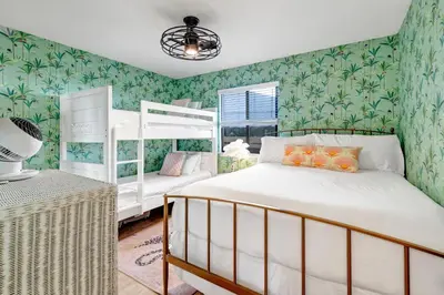 a bedroom with two bunk beds and green wallpaper at Gulf Front, Seagrove Beach, Sleeps 6, 1st floor, private beach access!! in Seagrove Beach